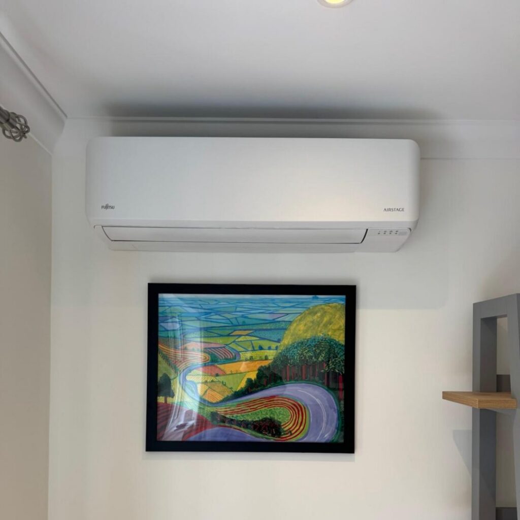 Air conditioning unit on the living room wall mounted above the central photograph