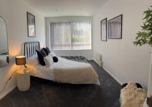 spare room, double bed with artwork on the walls, black and neutral colour schemev